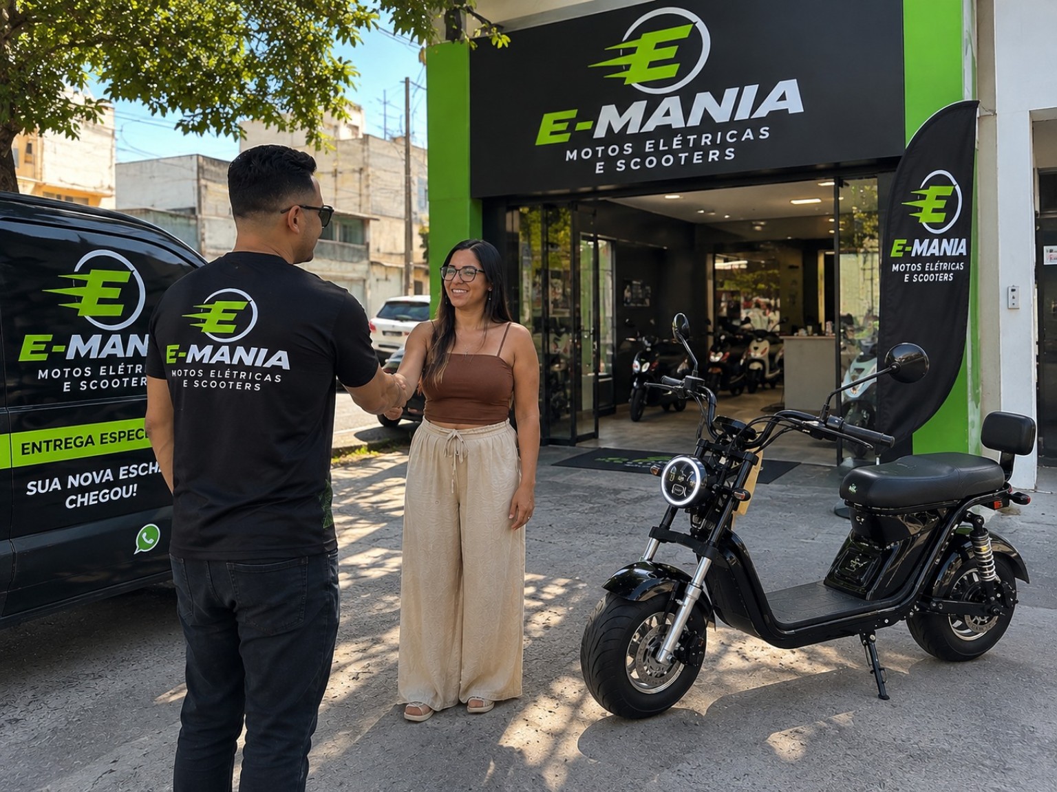 Duas pessoas em frente à fachada da E-Mania, com scooter e veículo da loja